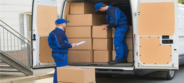 two furniture movers Dallas–Fort Worth metroplex loading a large chair onto a moving truck
