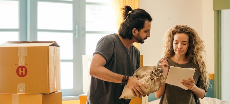 Happy couple packing boxes while discussing why people are moving from Dallas–Fort Worth metroplex to Austin