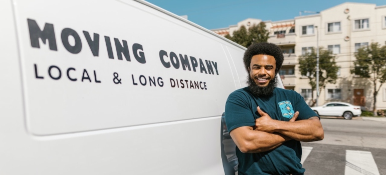 A professional mover next to a moving van